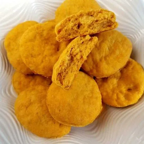 A pile of sweet potato biscuits sitting in a large white fluted bowl.