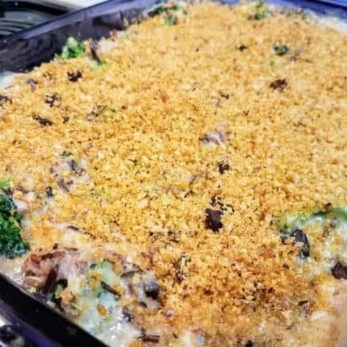 Broccoli, black bean, and cheesy wild rice casserole in a Pyrex baking dish on a stove.