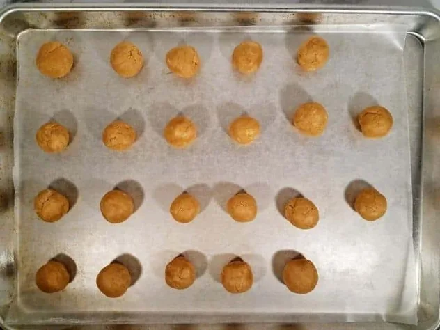 Chocolate Peanut Butter Balls Process Step 3 3/4" uncoated peanut butter balls on a wax paper lined baking tray prior to refrigeration.