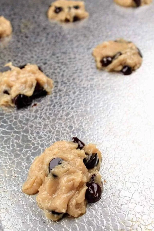 Dairy Free Chocolate Chip Cookies Process Step 4 Cookie dough scooped onto a textured aluminum baking sheet prior to baking.