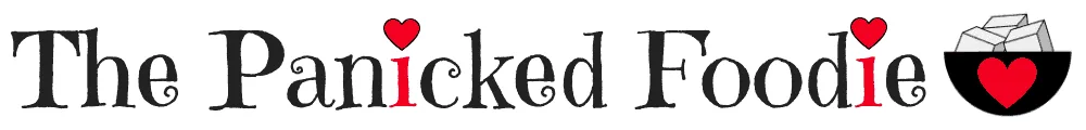 At the top of the blog's homepage are the words 'The Panicked Foodie,' with the i's colored red and dotted with red hearts. At the end is a black mixing bowl with a red heart on it that contains three sugar cubes.