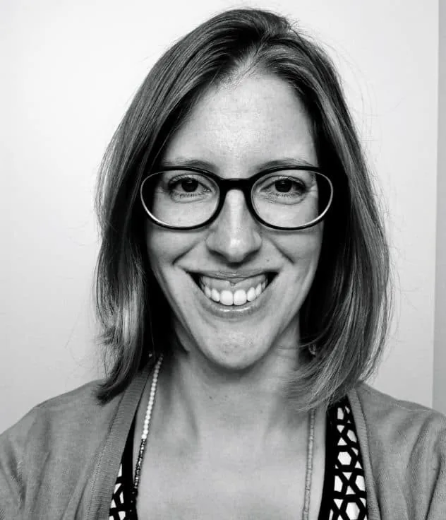 An above the shoulders black and white photo of me. I have chin length hair and circular black rim glasses on.