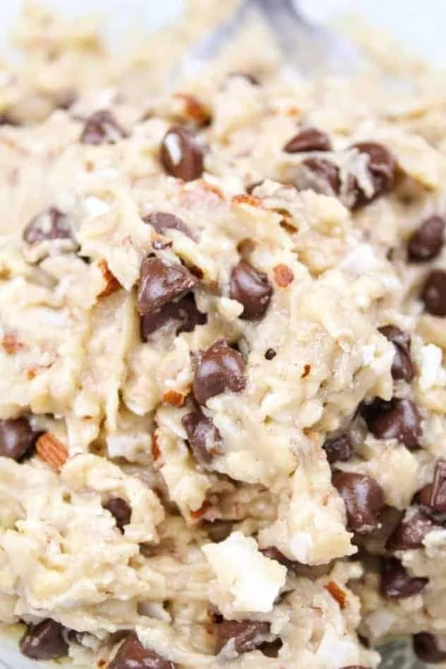 Chocolate chips folded into the dough in a large glass bowl.