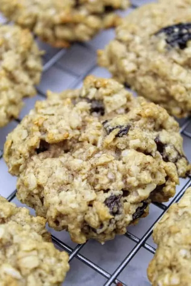 Vegan oatmeal raisin cookies sitting on a wire rack to cool after baking.